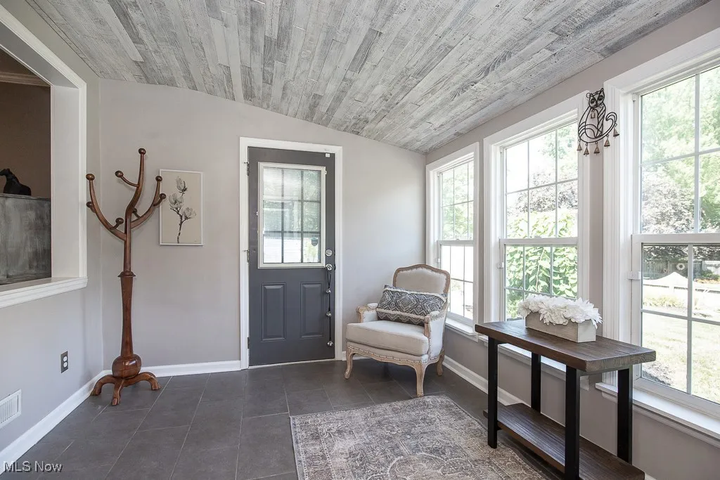 Sitting room with lofted ceiling, wooden ceiling, and dark tile patterned floors
