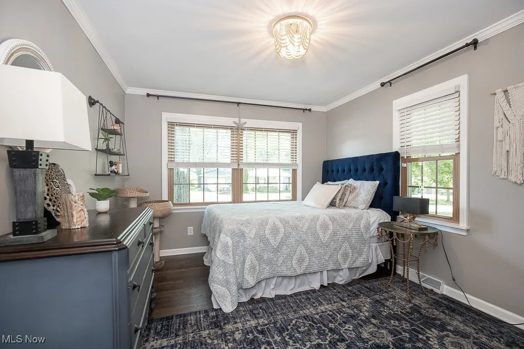 Bedroom featuring ornamental molding and dark wood-style floors