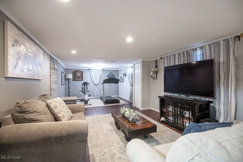 Living area with wood finished floors, crown molding, and recessed lighting