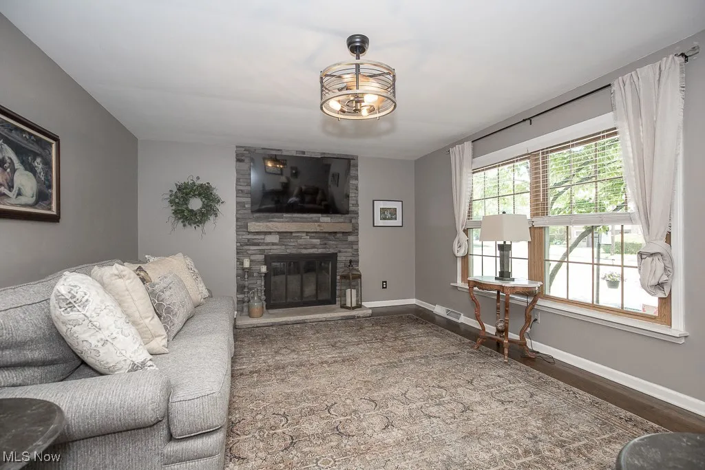 Living area with a stone fireplace and wood finished floors
