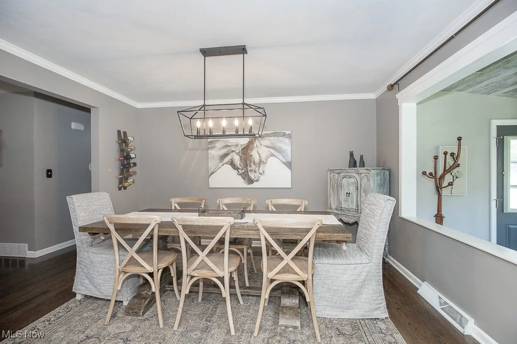 Dining room with ornamental molding and wood finished floors