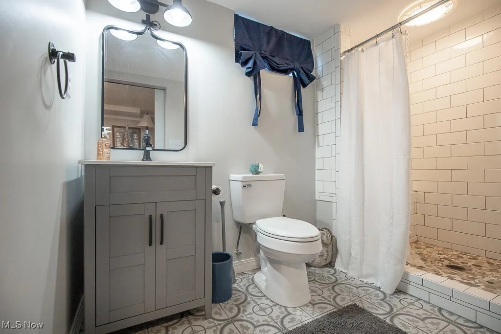 Full bath with tiled shower and vanity