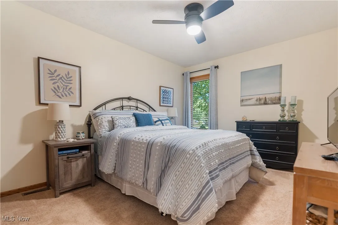Bedroom featuring light colored carpet and a ceiling fan