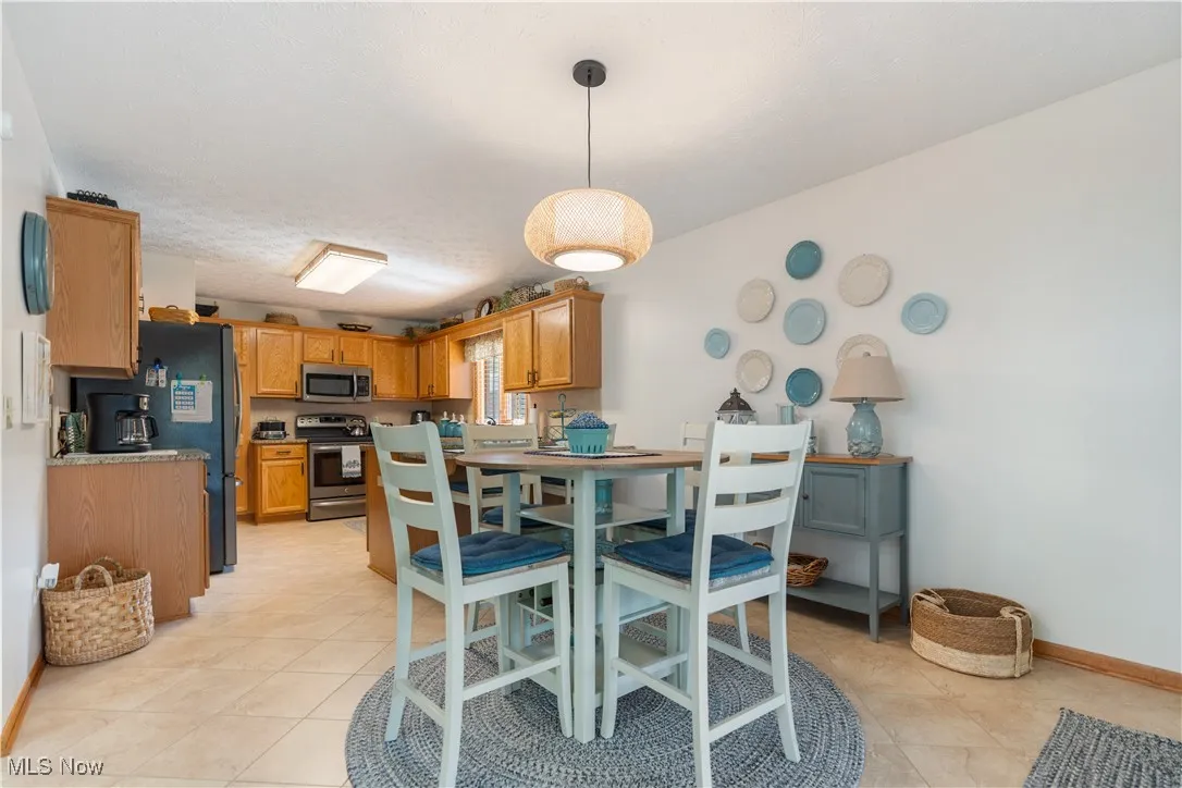 Dining space with baseboards and light tile patterned floors