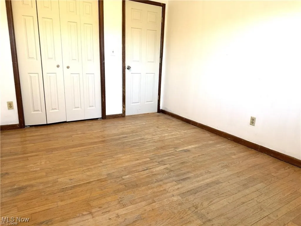 Unfurnished bedroom with light wood-style floors and a closet
