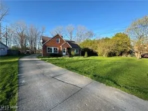 View of front of home with a front yard and driveway