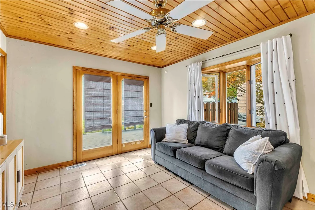 Living room featuring wood ceiling, light tile patterned floors, recessed lighting, and a ceiling fan
