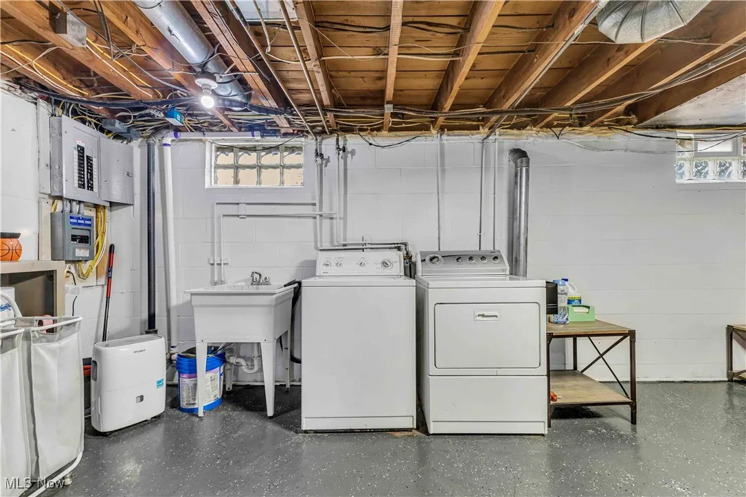 Laundry room featuring independent washer and dryer and electric panel