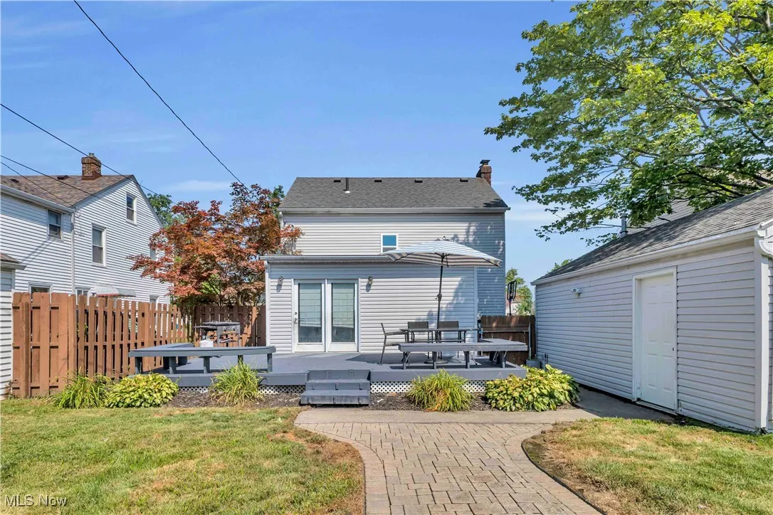 Back of property with a wooden deck and a chimney