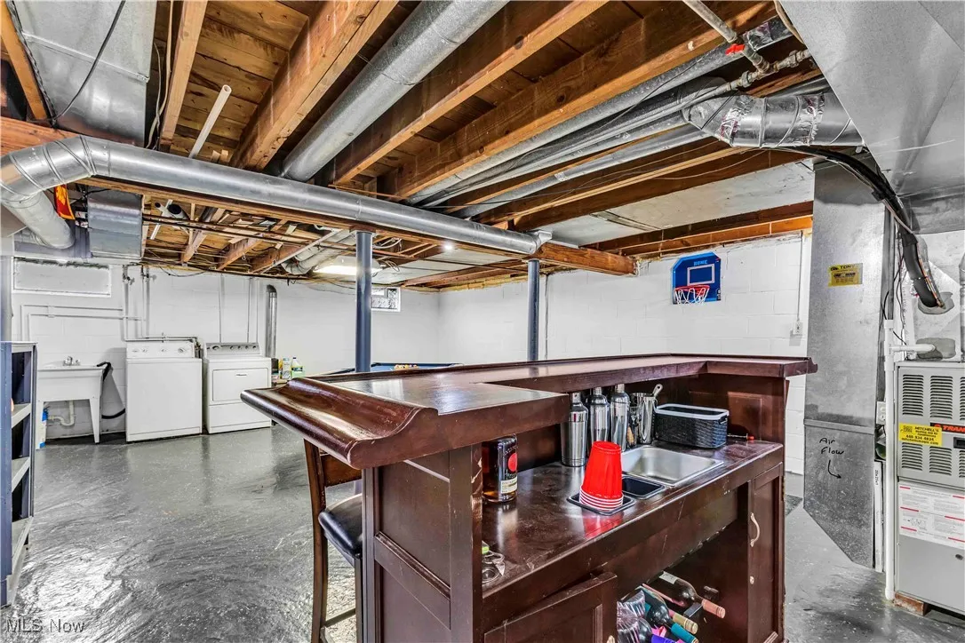 Unfinished below grade area featuring washing machine and dryer and heating unit