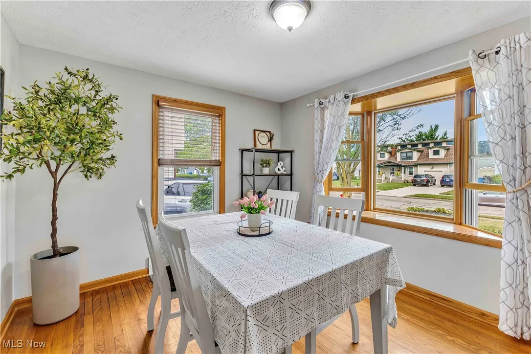 Dining space with a textured ceiling and light wood finished floors