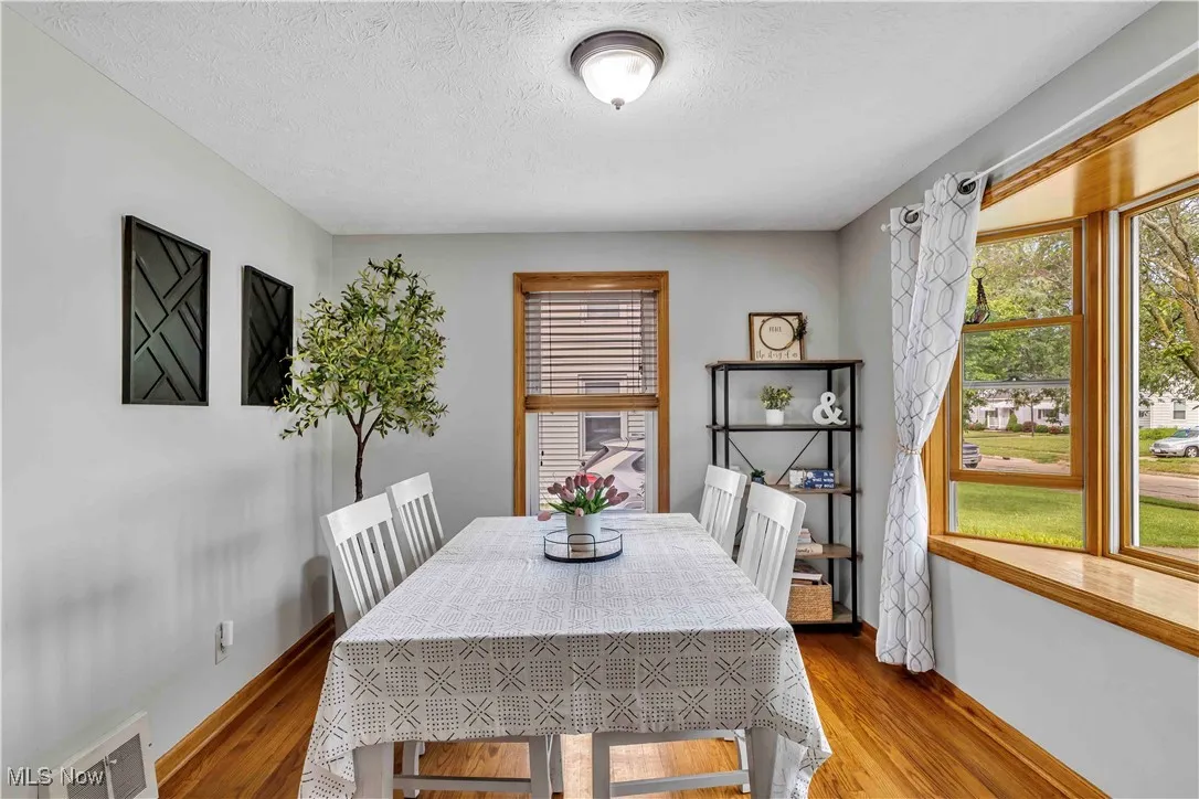 Dining area featuring wood finished floors and a textured ceiling