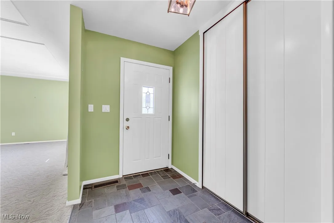 Entrance foyer with baseboards and stone finish flooring