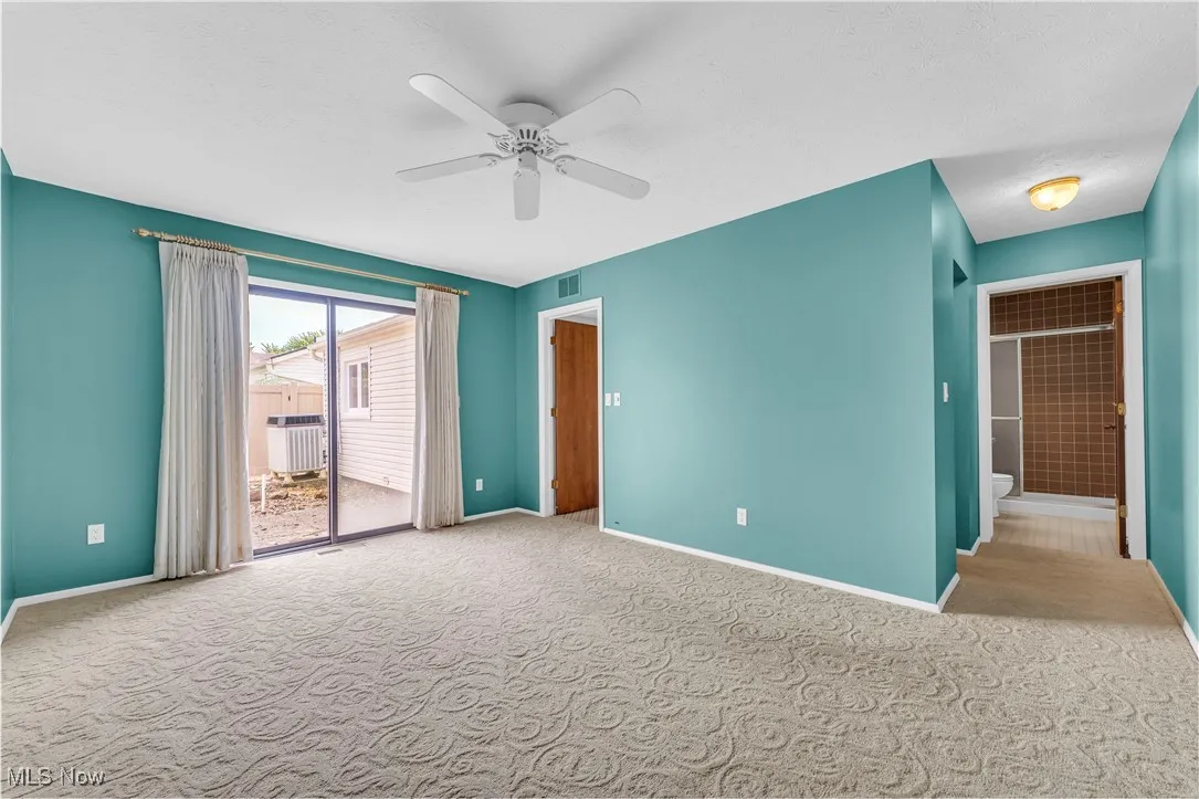 Unfurnished bedroom featuring carpet, access to outside, and ceiling fan