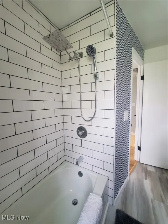 Bathroom with bathing tub / shower combination and wood finished floors