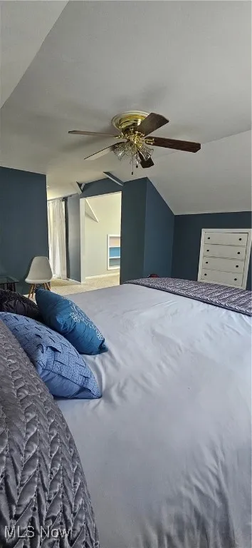 Bedroom with a ceiling fan and vaulted ceiling