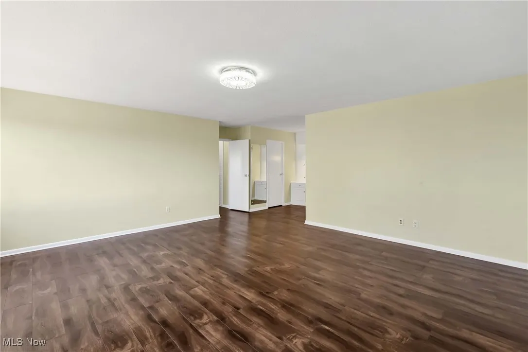 Empty room with dark wood finished floors and baseboards