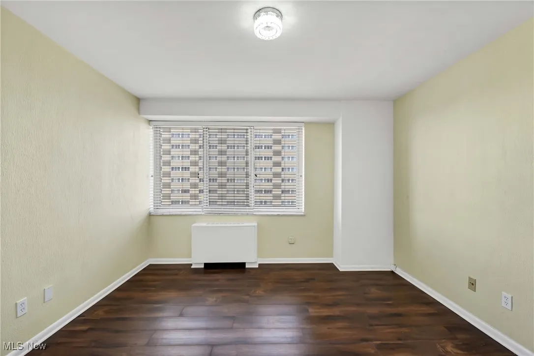 Spare room featuring baseboards and wood finished floors