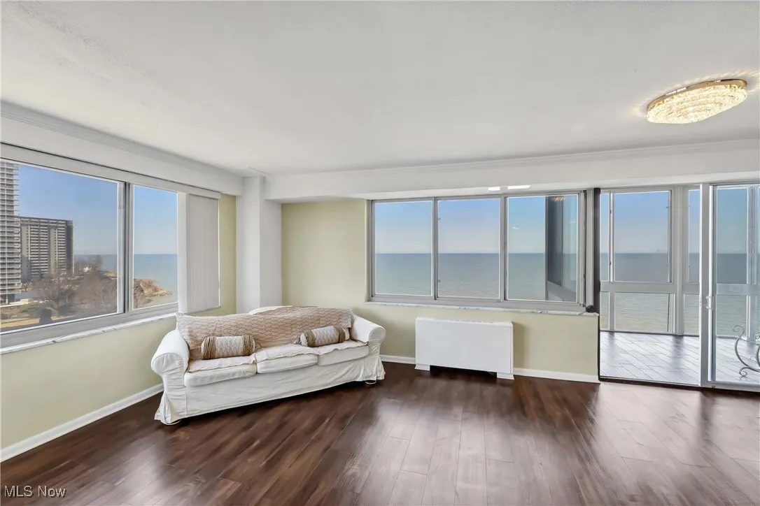 Living room with baseboards, radiator, and wood finished floors