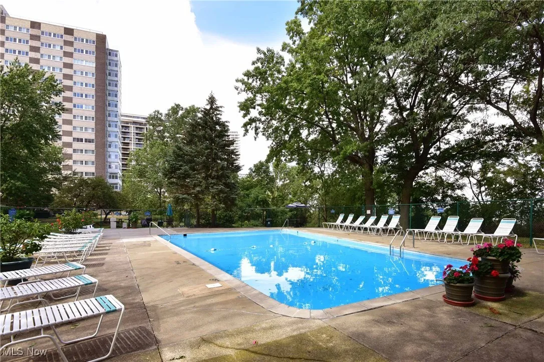 Community pool featuring a patio and fence