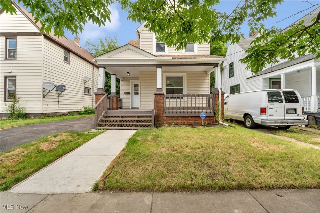 View of front of property with covered porch and a front yard