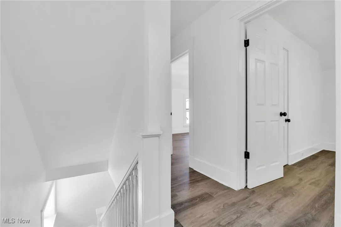 Corridor featuring wood finished floors and an upstairs landing