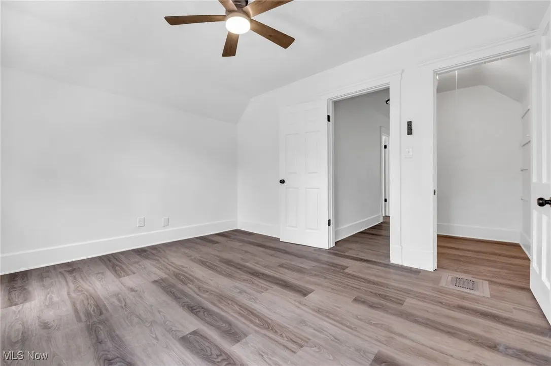 Bonus room with lofted ceiling, ceiling fan, and wood finished floors