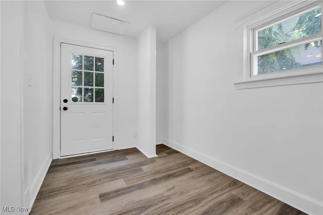 Doorway with wood finished floors and recessed lighting