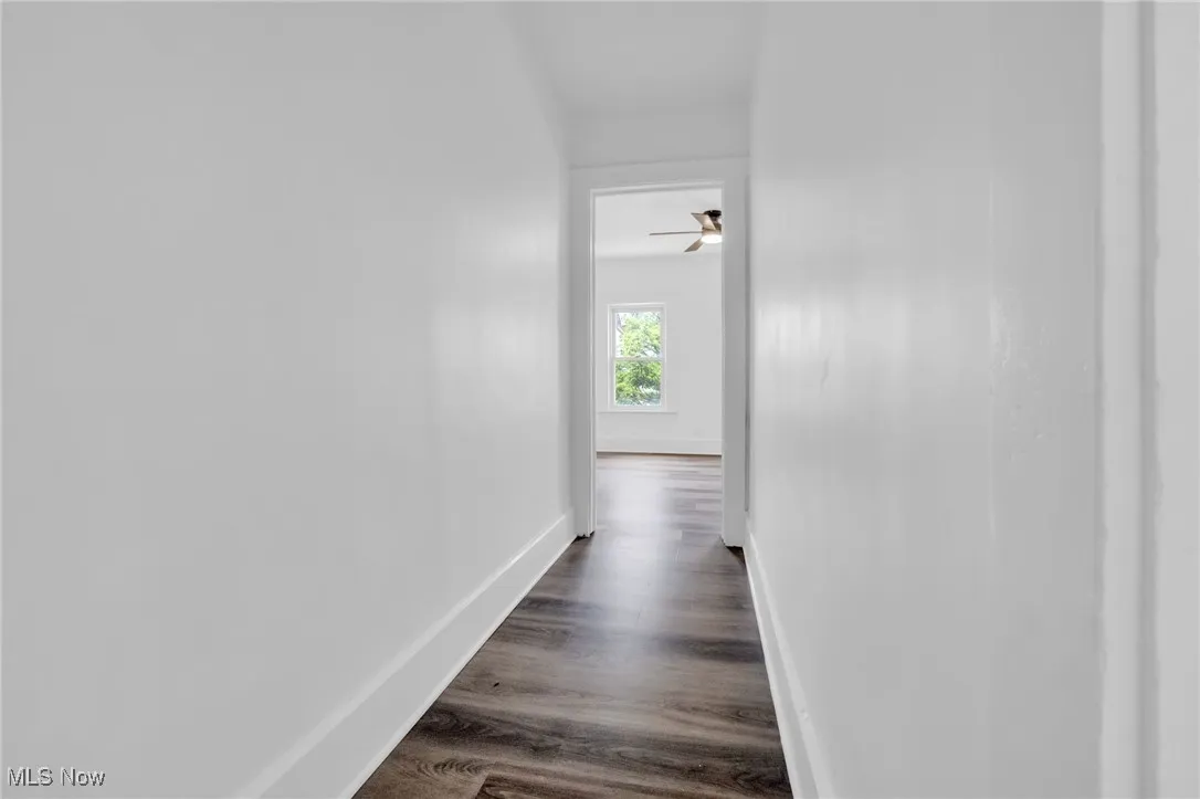 Hall featuring baseboards and dark wood finished floors