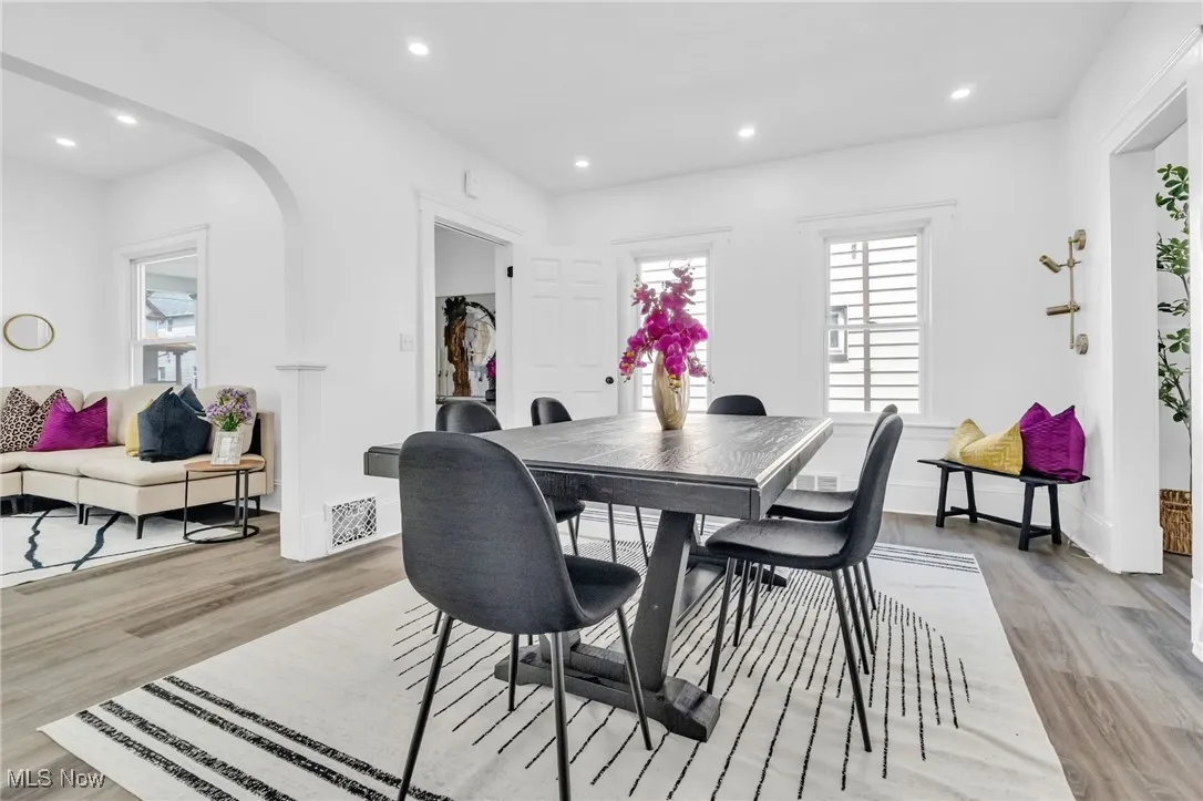 Dining space with healthy amount of natural light, light wood-type flooring, arched walkways, and recessed lighting