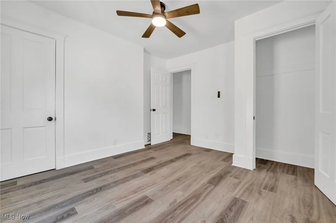 Unfurnished bedroom featuring wood finished floors, a closet, and ceiling fan