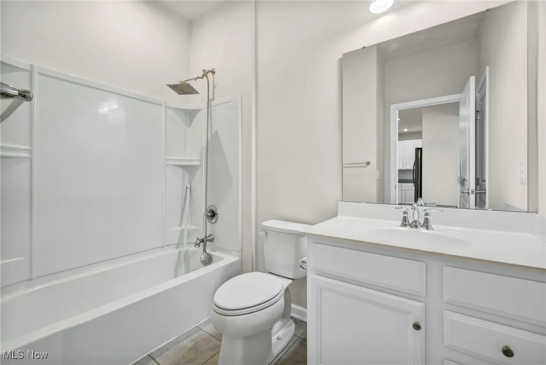 Bathroom with vanity, tile patterned floors, and washtub / shower combination