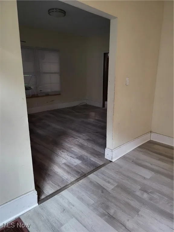 Empty room featuring baseboards and wood finished floors