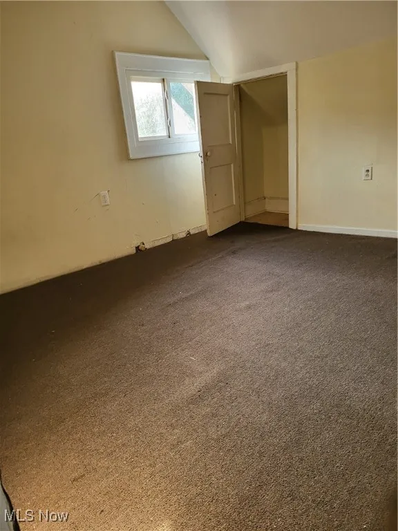 Additional living space with vaulted ceiling and carpet floors