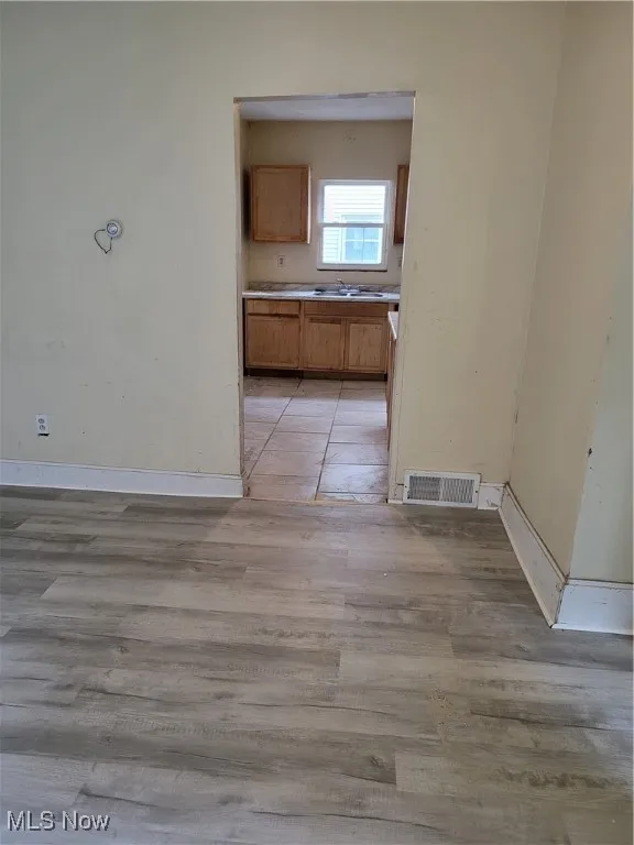 Unfurnished dining area with baseboards and light wood-style flooring