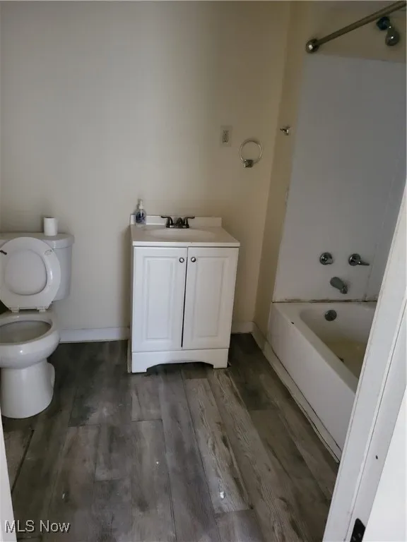 Bathroom featuring vanity, bathing tub / shower combination, and wood finished floors. Main Level