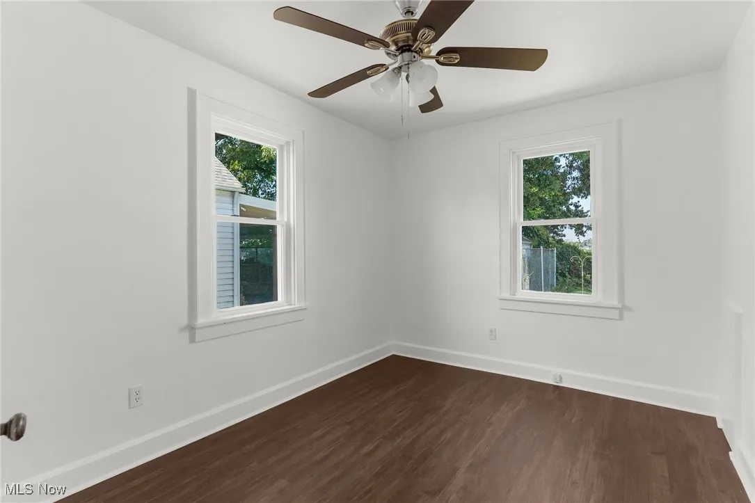 Spare room with dark wood finished floors and ceiling fan
