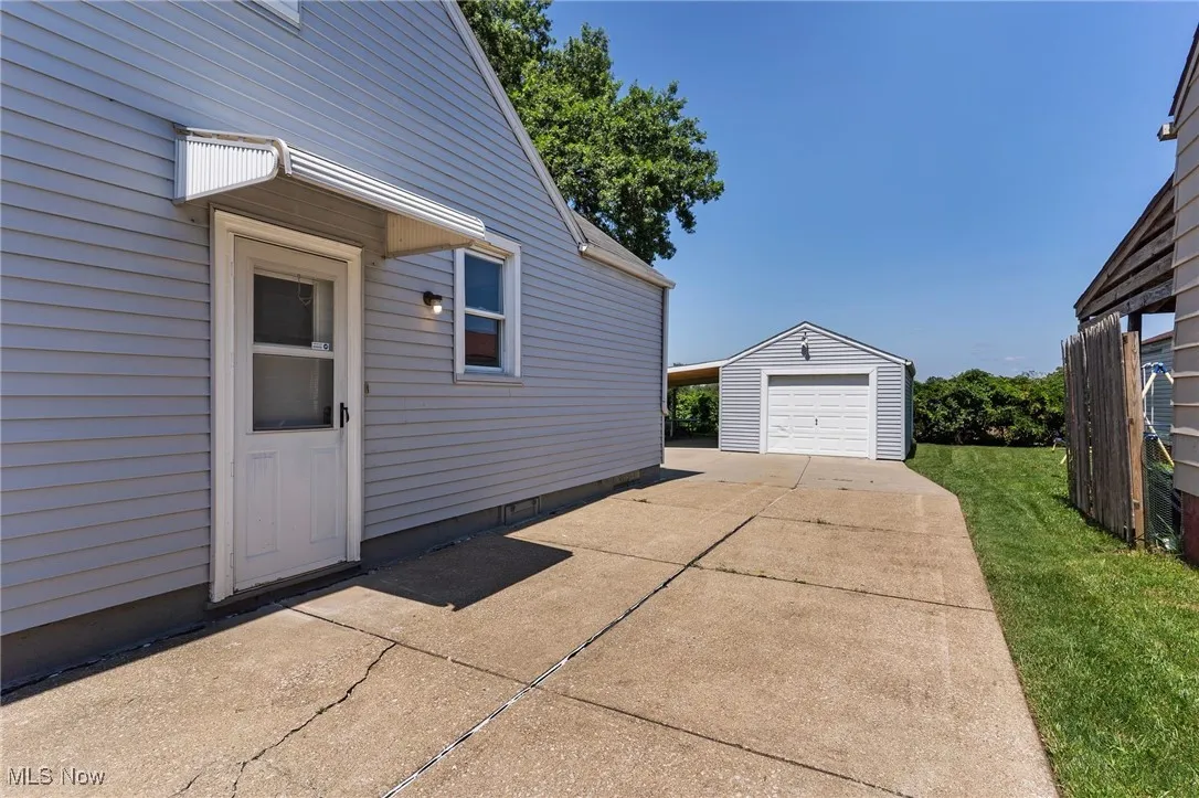 View of side of home with an outbuilding, driveway, and a garage