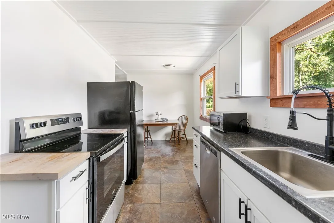 Kitchen featuring appliances with stainless steel finishes, white cabinets, and butcher block countertops