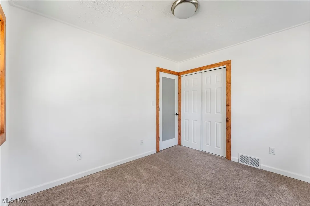 Unfurnished bedroom with carpet and a closet