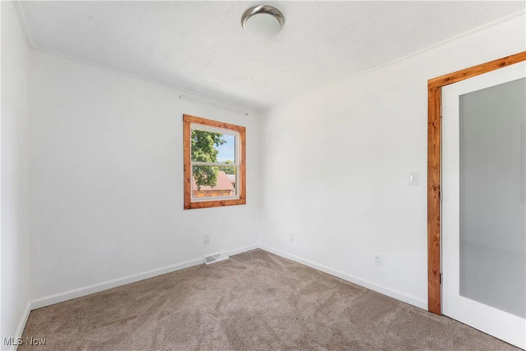 Carpeted spare room featuring baseboards