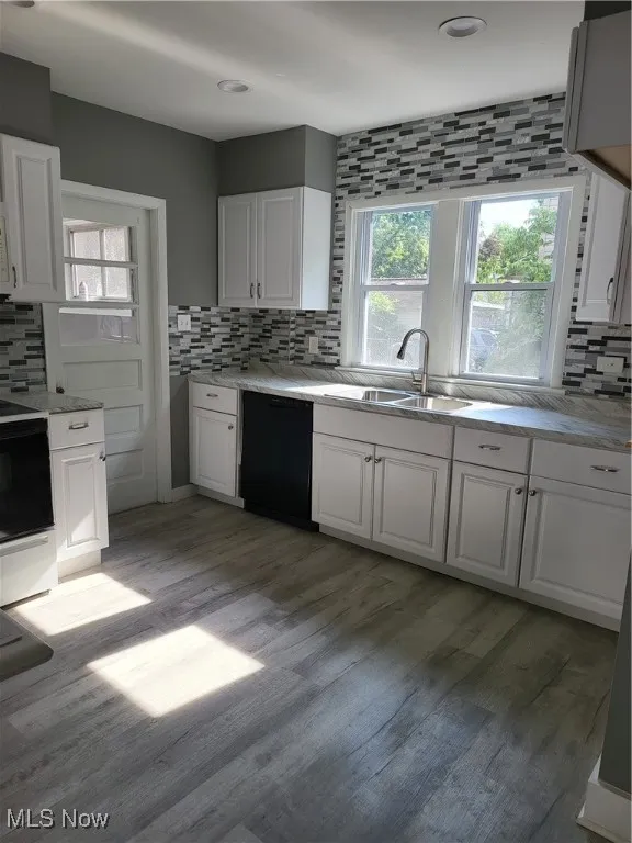 Kitchen featuring decorative backsplash, range, and white cabinets