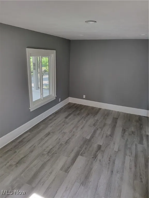 Unfurnished room with baseboards and wood finished floors