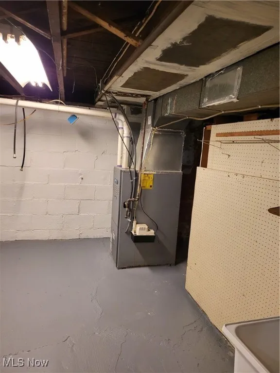 Unfinished basement featuring heating unit