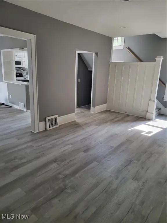 Unfurnished dining area featuring wood finished floors and stairs