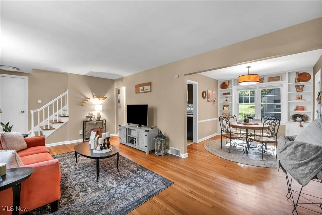 Living room featuring staircase to second floor and view into dining room.