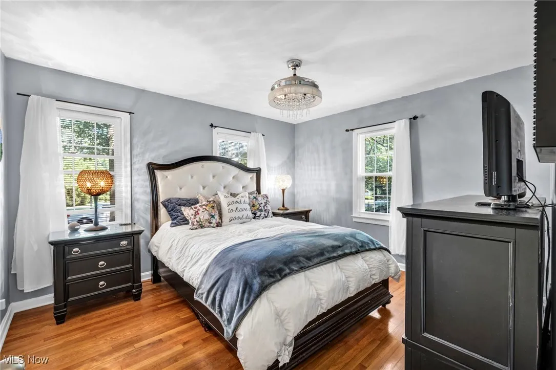 Entrance to first floor bedroom showcasing hardwood floors and 3 windows for lots of natural light.