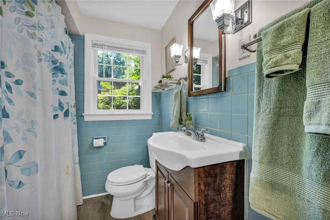 Second floor full bathroom with tile walls, newer vanity, LVP flooring and tub/shower combo.