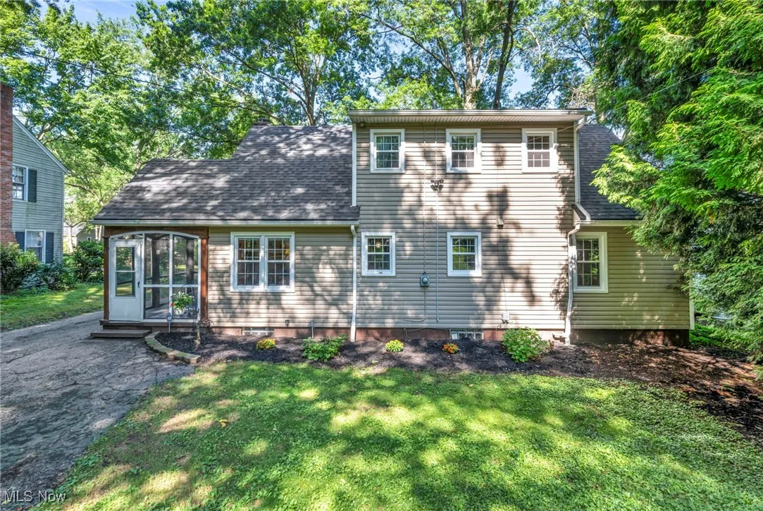 Back of house featuring new roof and back of attached screened-in porch.