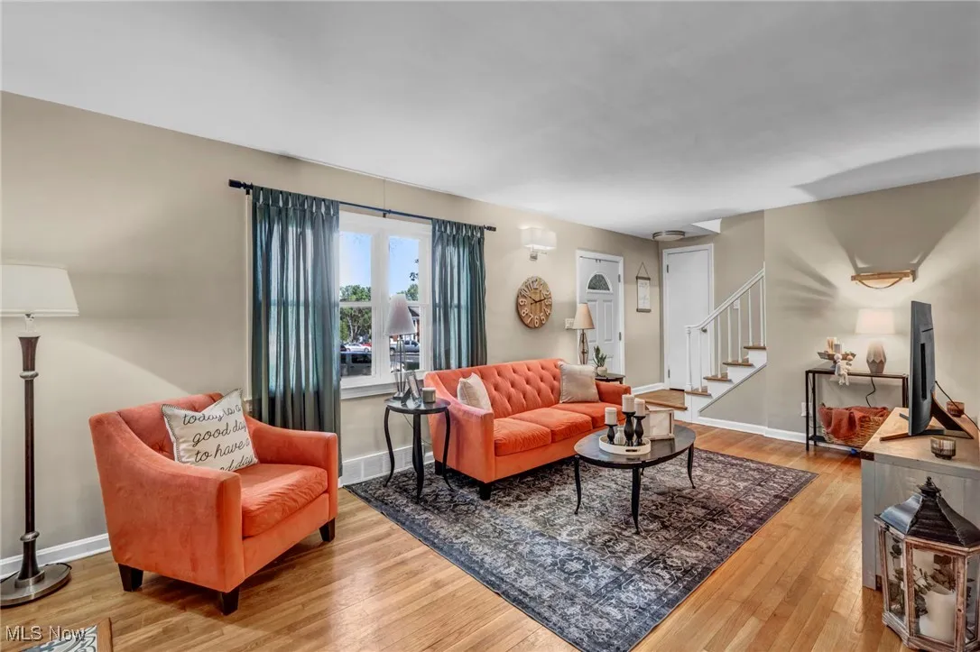 Living room showcasing beautiful hardwood flooring and front windows for lots of natural light.